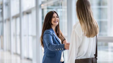 Kundenberater:in im Vertrieb: Zwei Frauen begrüßen sich